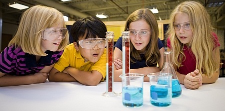 At NanoDays in Nebraska, four students look at beakers full of liquid